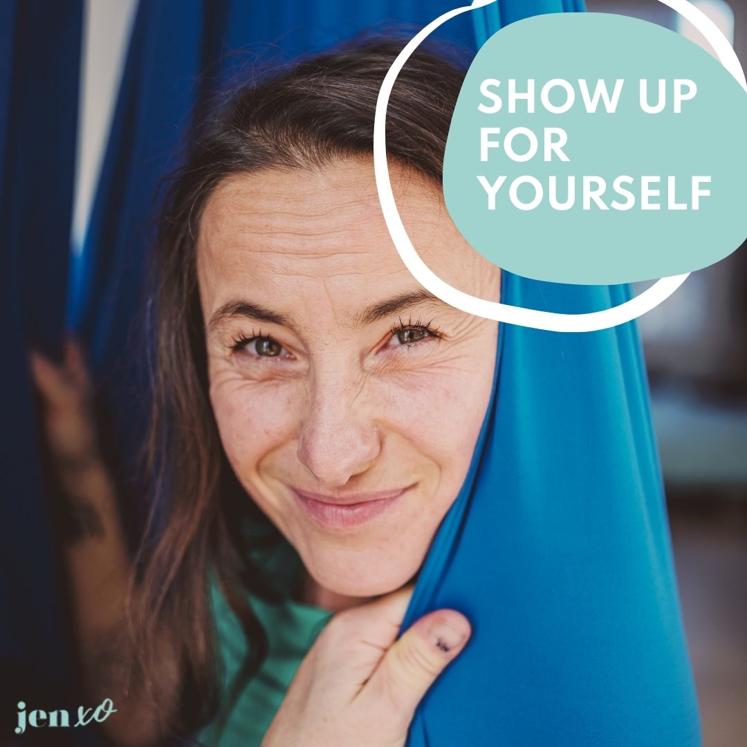 A beautiful midlife woman with brown hair in a blue hammock looking directly at the camera